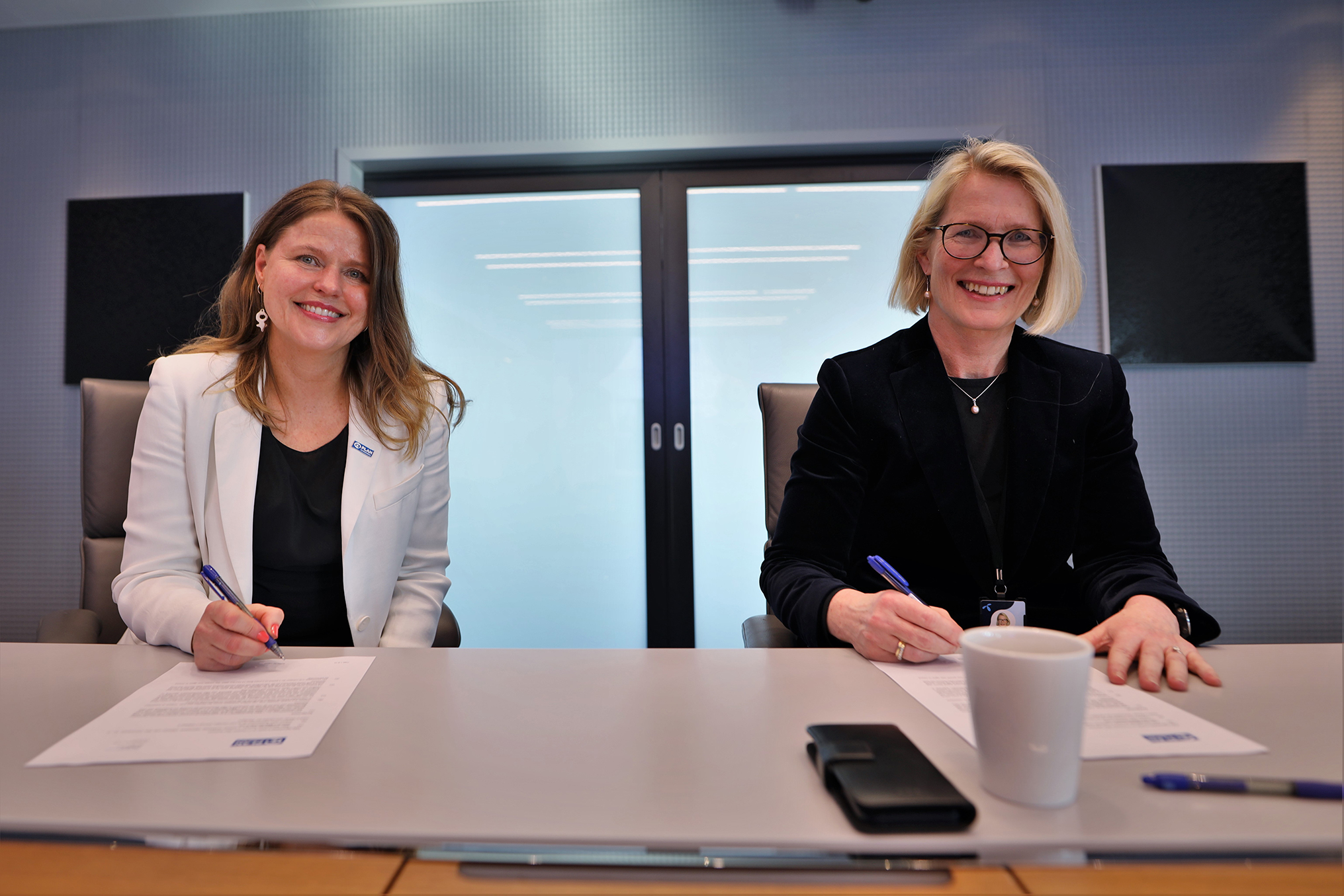 Two women signing a paper